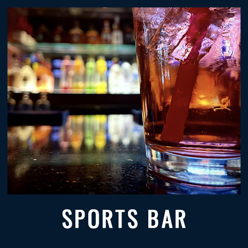Close-up of a cocktail with a straw on a bar counter and colorful bottles with "SPORTS BAR" in