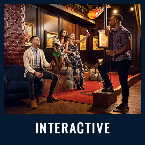 People posing for photos and having fun in a themed interactive exhibit with dramatic lighting