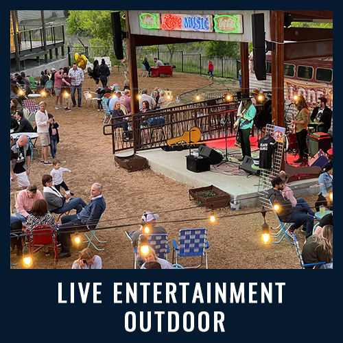 Crowd enjoying live outdoor music with string lights, a stage and casual atmosphere